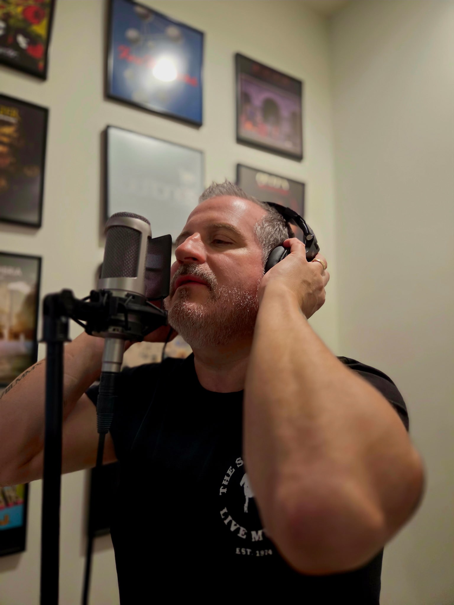Episode In Apathy artist recording vocals in a studio with headphones and a microphone
